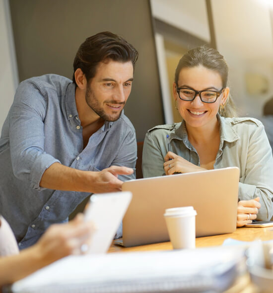 Two colleagues reviewing campaign performance on a laptop